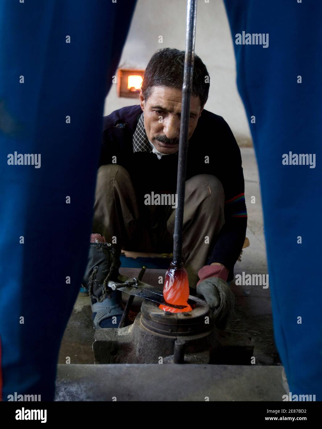 Glassblowers work at a glass workshop in south of Tehran February 22, 2009. REUTERS/Raheb Homavandi (IRAN) Stock Photo
