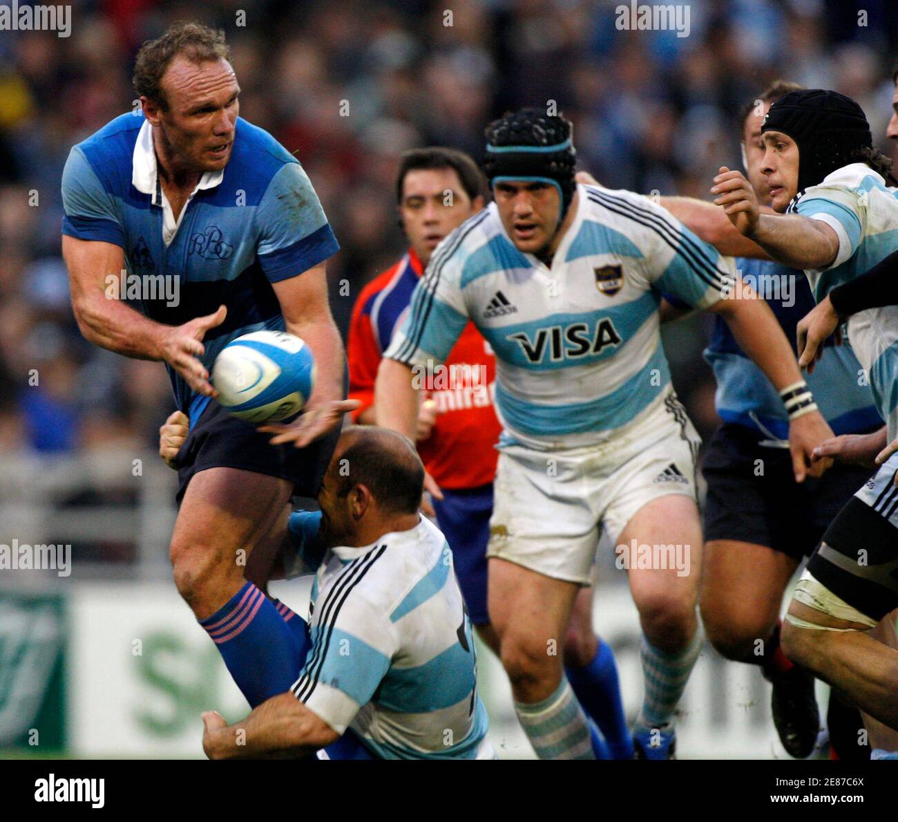 Brian Liebenger (L) from the Barbarians passes the ball under pressure of  Mario Ledesma (bottom) and Genaro Fessia (C) from Los Pumas, during their  international friendly rugby union match in Buenos Aires,
