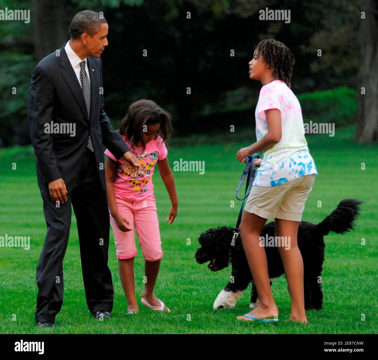 U.S. President Barack Obama is welcomed by his daughters Sasha (L) and Malia and their dog Bo on his return to Washington after a day trip to Ohio and Pennsylvania, where he participated in economic rallies, September 15, 2009.   REUTERS/Mike Theiler (UNITED STATES POLITICS) Stock Photo