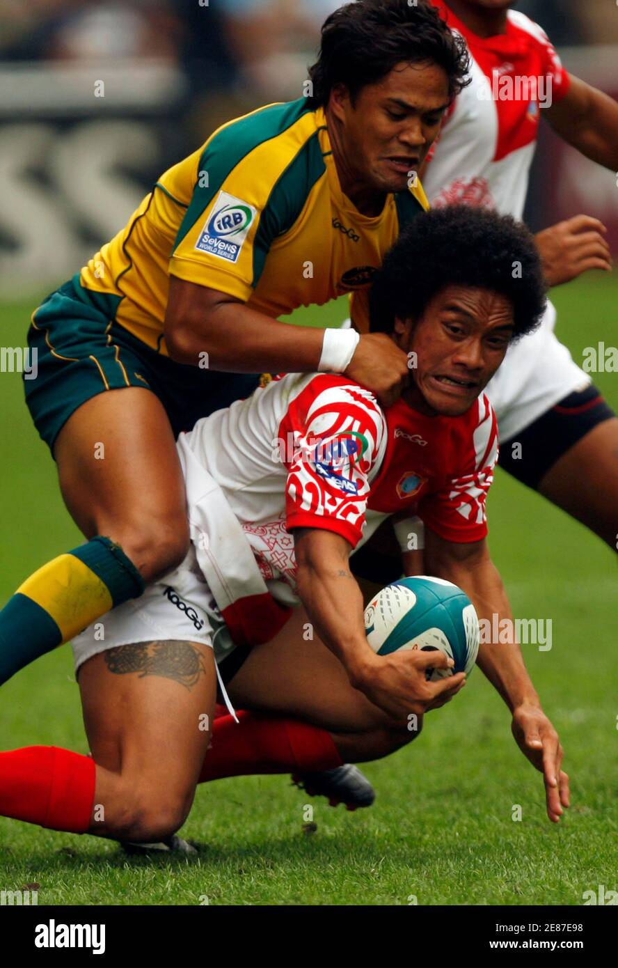 Australia's Brackin Karauria-Henry (top) is tackled by Tonga's Etisoni Hefa during the preliminaries of the Hong Kong Sevens rugby tournament March 27, 2010.   REUTERS/Tyrone Siu  (CHINA - Tags: SPORT RUGBY) Stock Photo