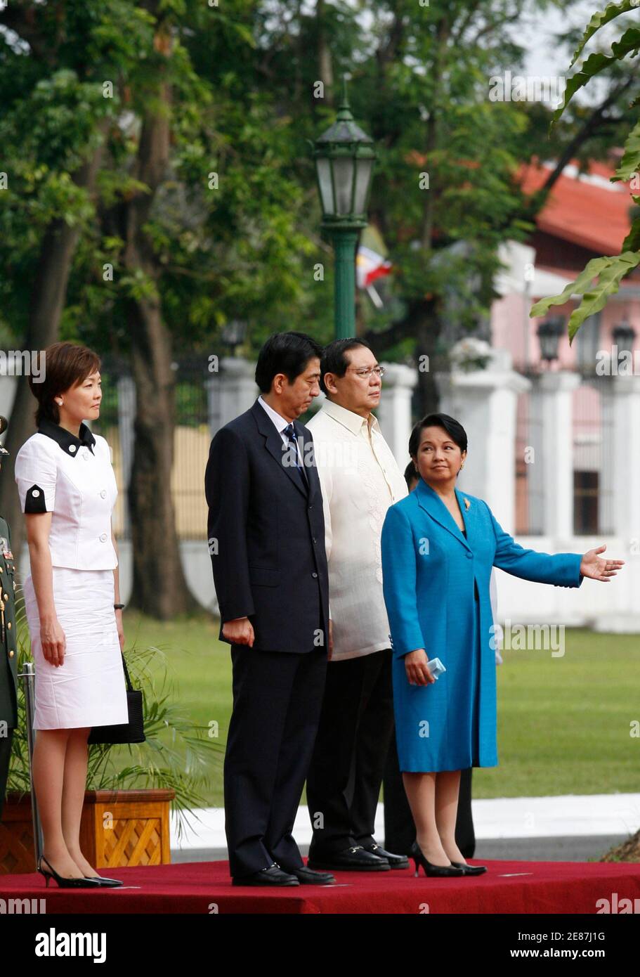 Philippine President Gloria Macapagal Arroyo (R) gestures to visiting  Japanese Prime Minister Shinzo Abe (2L), as Abe's wife Akie (L) and  Arroyo's husband Jose Miguel stand nearby, upon Abe's arrival at the