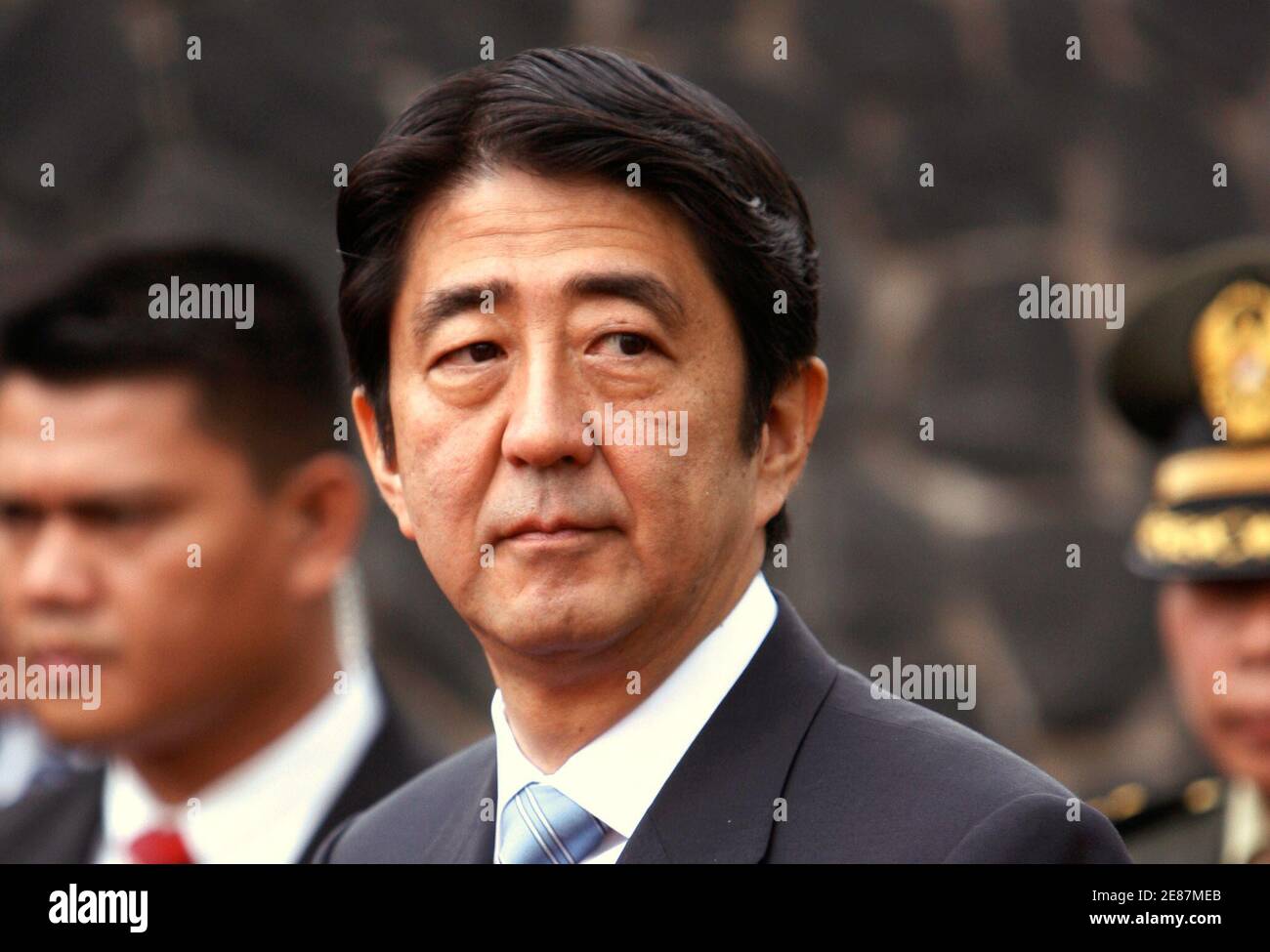 Japan's Prime Minister Shinzo Abe (front) is seen after praying in front of thea grave of a Japanese soldier at the Hero Cemetery in Jakarta August 21, 2007.   REUTERS/Beawiharta (INDONESIA) Stock Photo