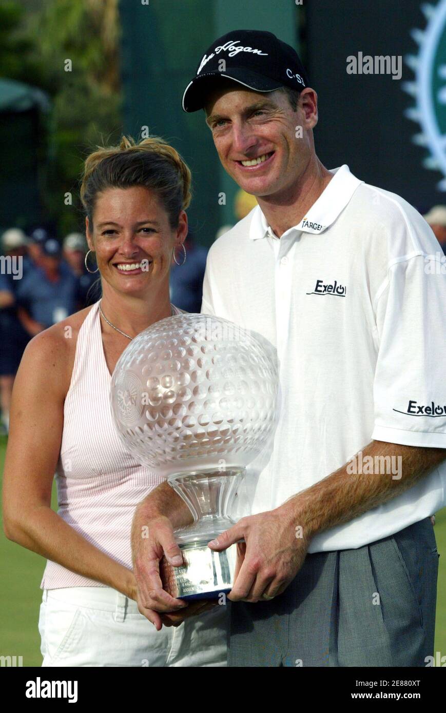 Jim Furyk of the U.S. and his wife Tabatha (L) hold a trophy after he won the Sun City Golf Challenge in Sun City, west of Johannesburg, in South Africa December 4, 2005. Furyk chipped in on the second extra hole of a sudden-death playoff to win the 25th Sun City Golf Challenge on Sunday. Furyk's birdie from 15-feet from the back of the par-four 18th green beat off Briton Darren Clarke and Australia's Adam Scott for the $1.2 million first prize. REUTERS/Juda Ngwenya Stock Photo