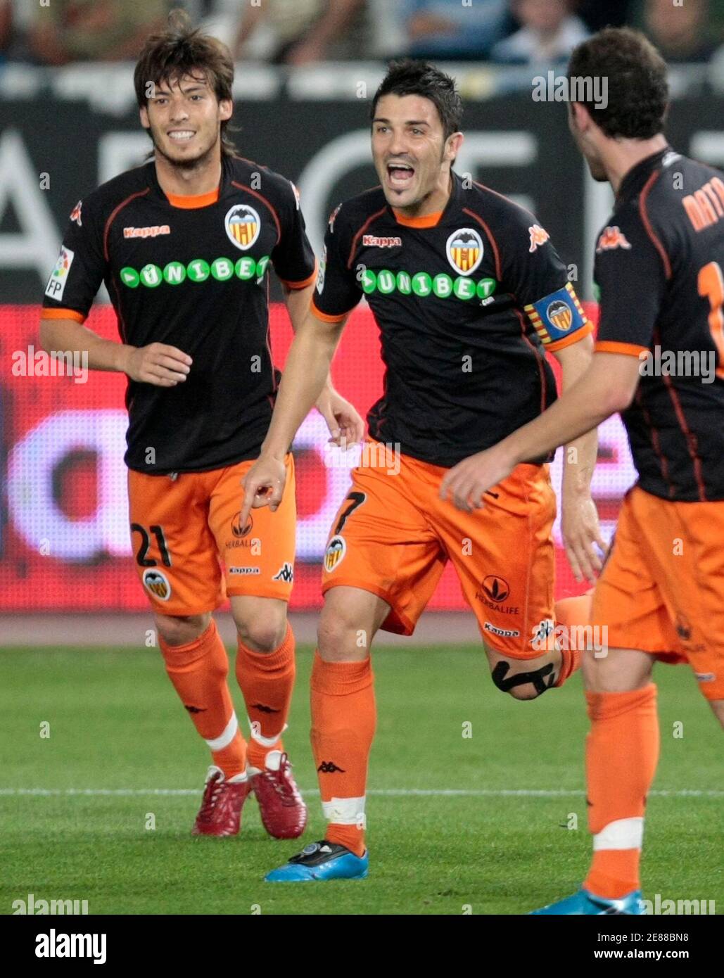 Valencia's David Villa celebrates after scoring a goal against Almeria as  he is joined by team-mates David Silva (L) and Juan Manuel Mata (R) during  their Spanish first division soccer match in