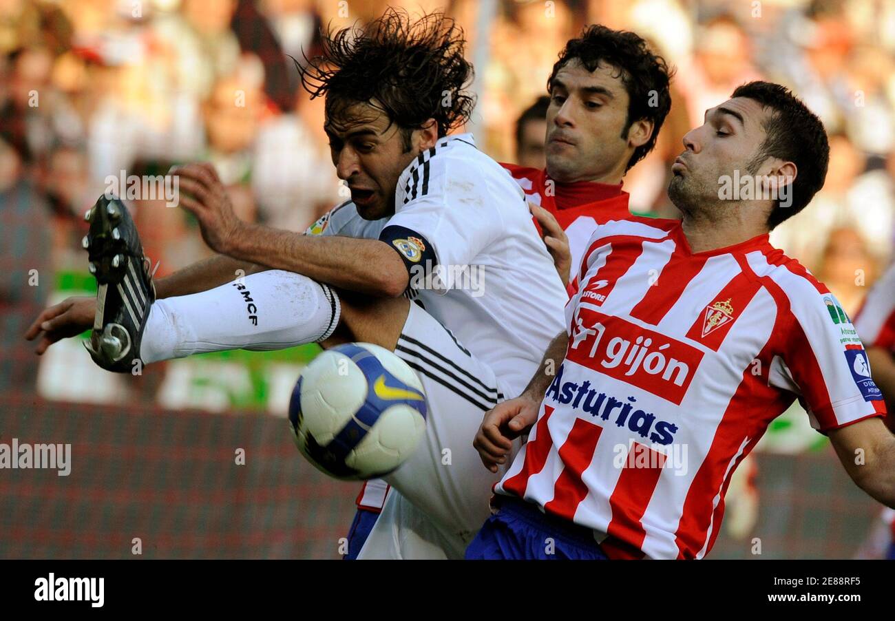 Real Madrid's captain Raul (L) and Sporting Gijon's David Barral fight for the ball during their Spanish first division soccer league match at El Molinon stadium in Gijon February 15, 2009. REUTERS/Eloy Alonso (SPAIN) Stock Photo