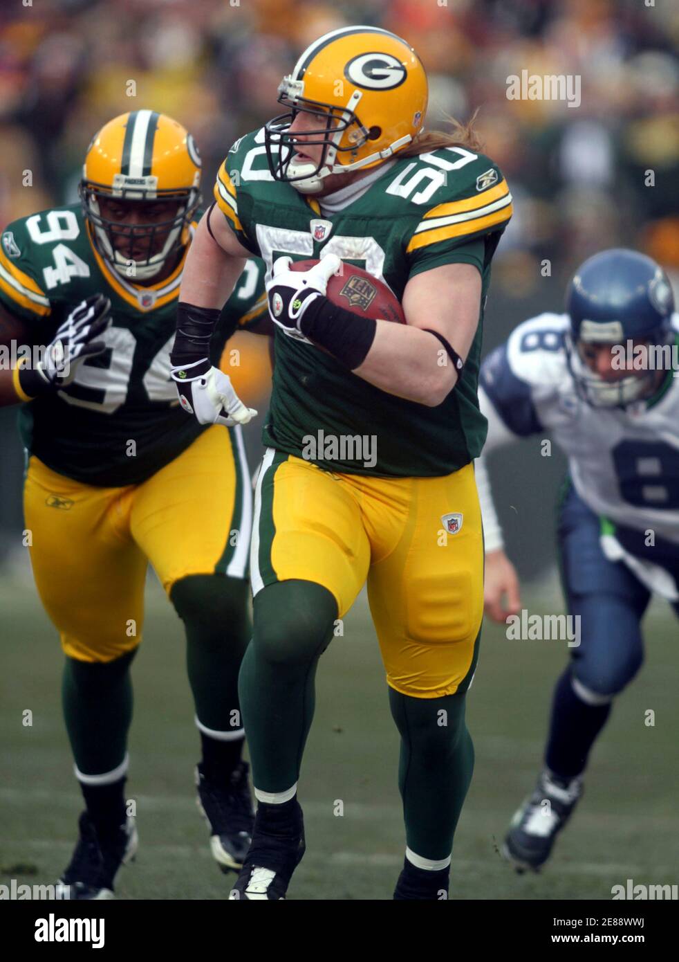 Green Bay Packers linebacker A.J. Hawk (50) runs an interception back with  Seattle Seahawks quarterback Matt Hasselbeck (8) in pursuit and defensive  end Jarius Wynn (94) following the play in the first