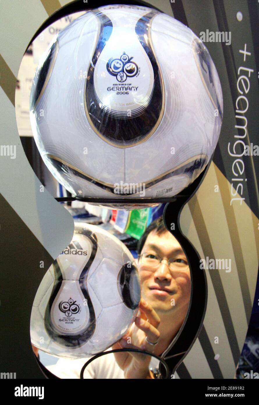 A Japanese shop clerk displays the official World Cup "Teamgeist" soccer  ball for sale at the 2006 FIFA World Cup Official Shop Operated under  licence by FamilyMart in Tokyo April 18, 2006.