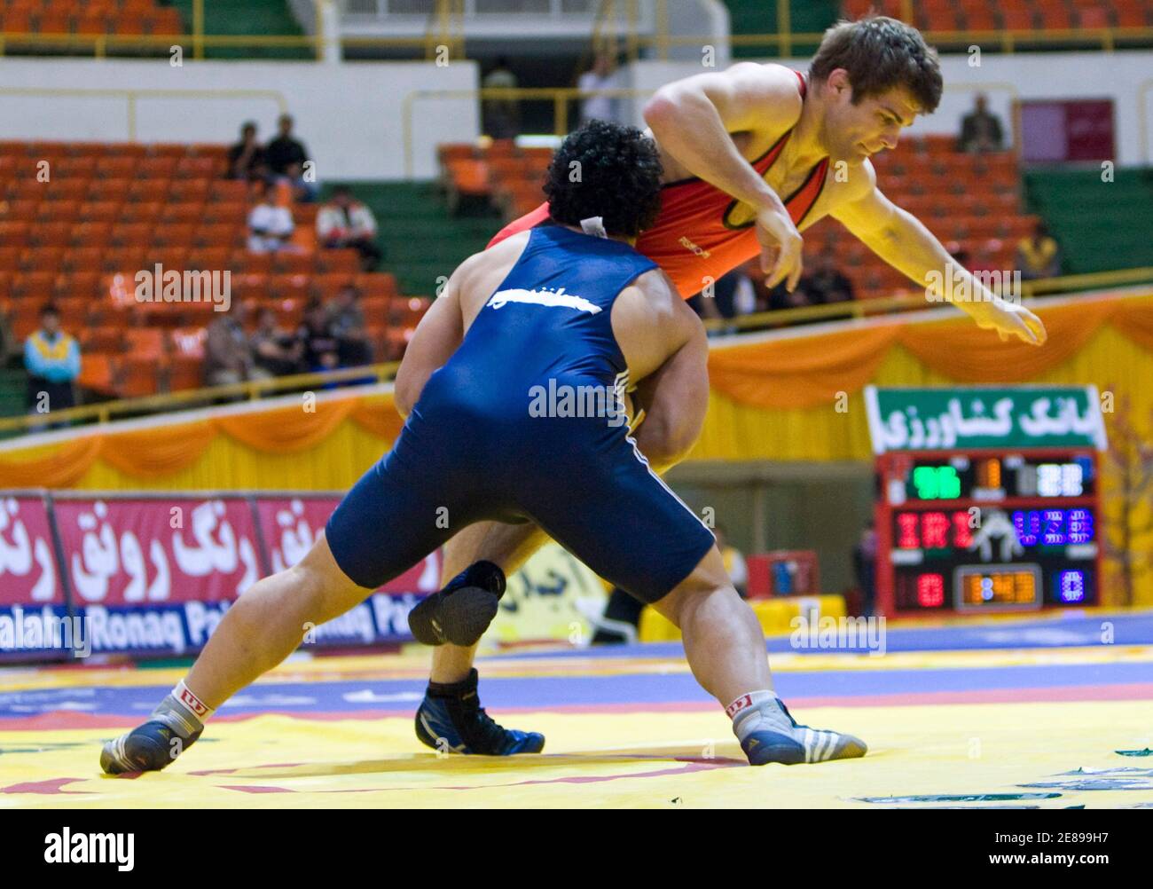 Michael Tamillow (in red) of the U.S. wrestles Rasoul Tavakoli of Iran in the 96kg weight class of the 29th Takhti Freestyle Wrestling Tournament in Tehran March 12, 2009. REUTERS/Raheb Homavandi (IRAN SPORT WRESTLING) Stock Photo