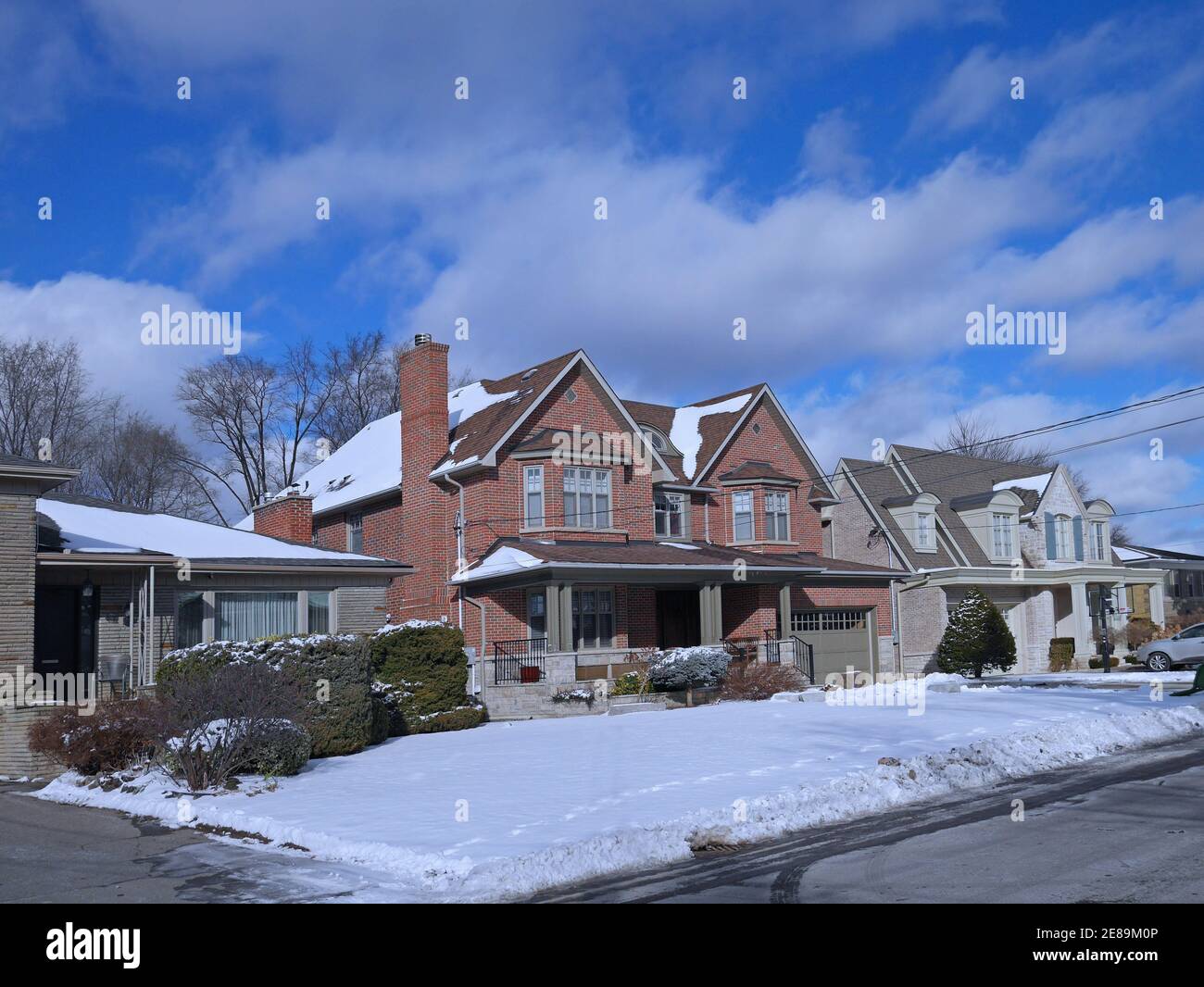 Suburban Residential neighborhood with single family houses with large front yards on a sunny day in winter Stock Photo