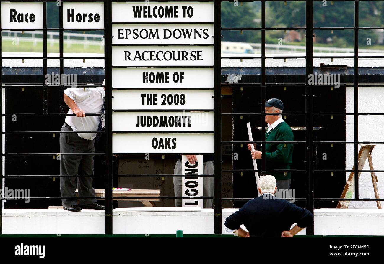 Ground staff members adjust the scoreboard before the start of the first race of the Epsom Derby Festival at Epsom Downs in Surrey, southern England June 6, 2008. REUTERS/Alessia Pierdomenico (BRITAIN) Stock Photo