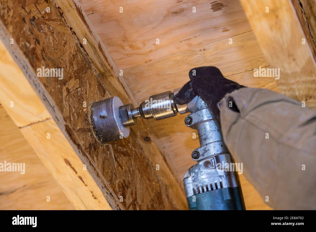 Pumping contractor for drilling hole in joist for ABS and PVC drain