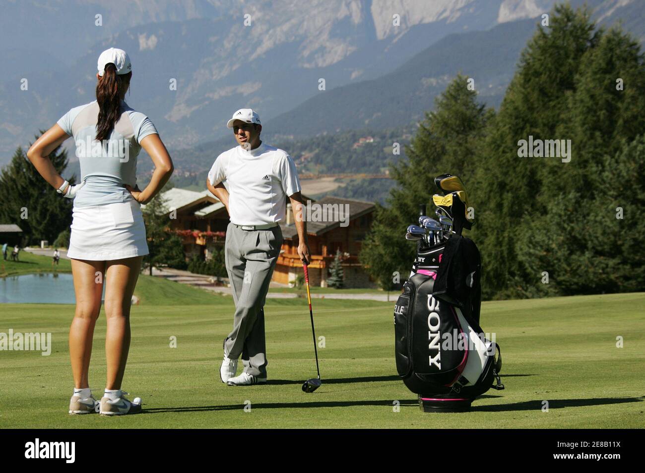 Sergio Garcia of Spain (R) discusses with Michelle Wie of the U.S. on the  fairway to the 14th hole during a training session for the European Masters  golf tournament in Crans-Montana September