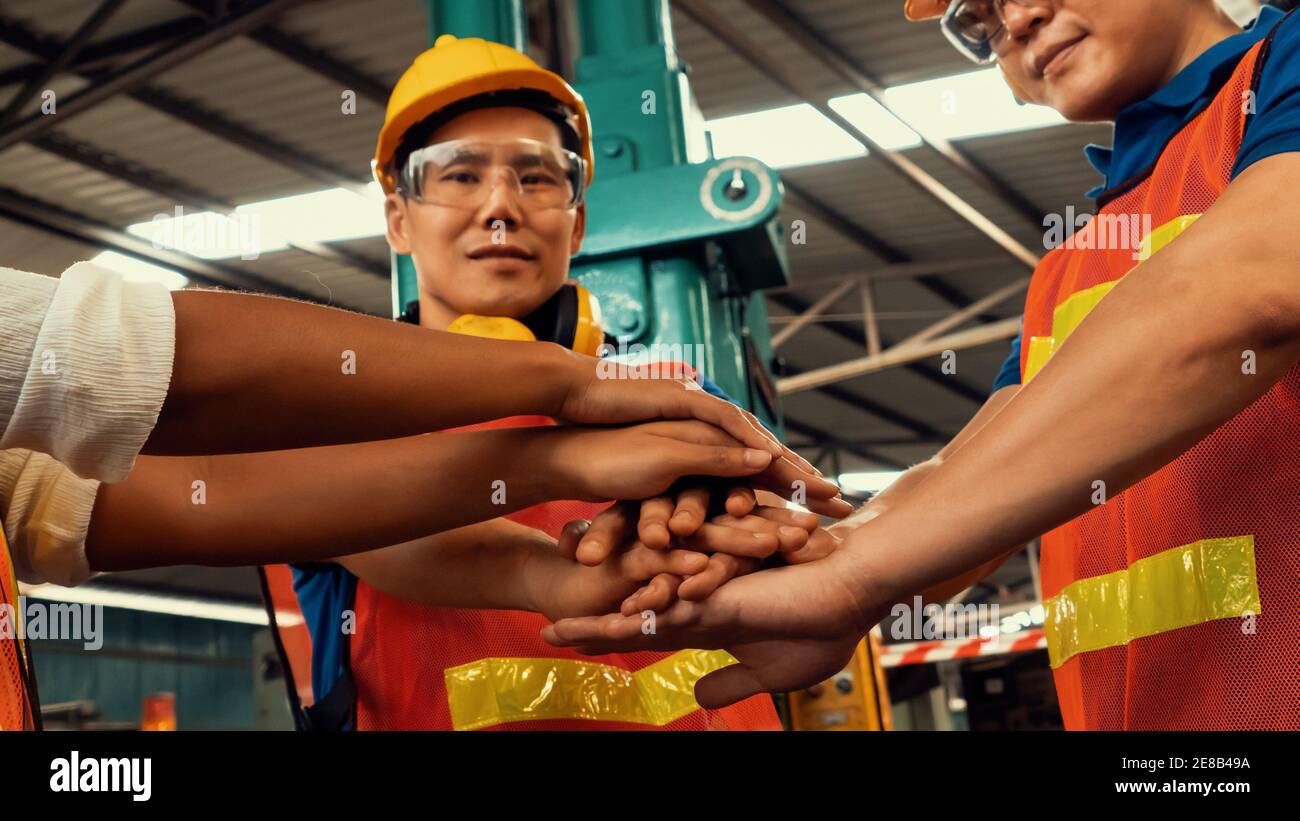 Team of skillful factory workers showing unity partnership and support