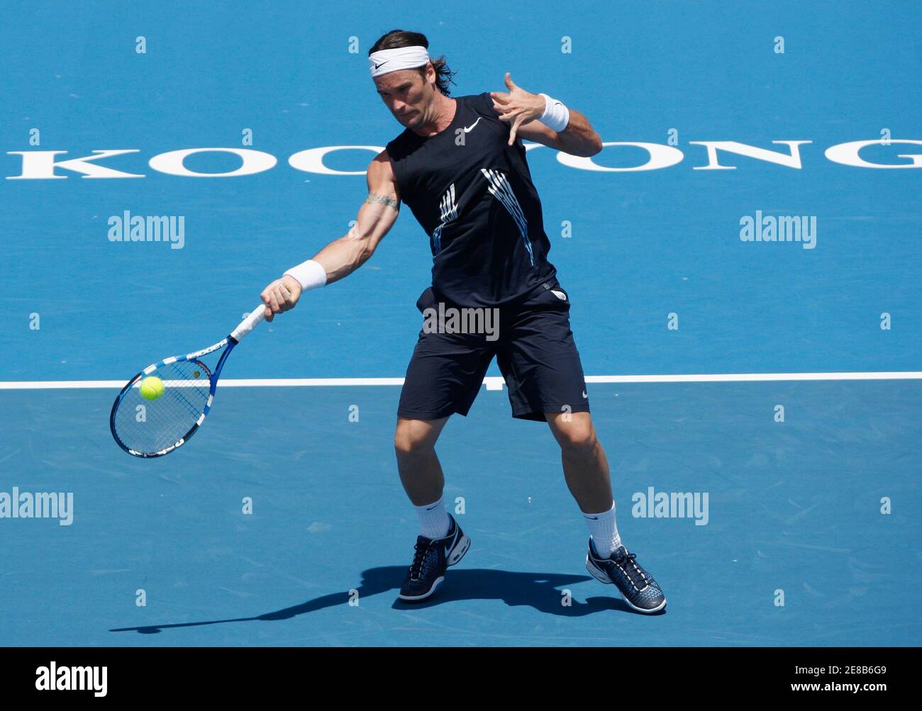 Spain's Carlos Moya hits a forehand to Switzerland's Roger Federer at the Kooyong  Classic tennis tournament in Melbourne January 14, 2009. REUTERS/Mick  Tsikas (AUSTRALIA Stock Photo - Alamy