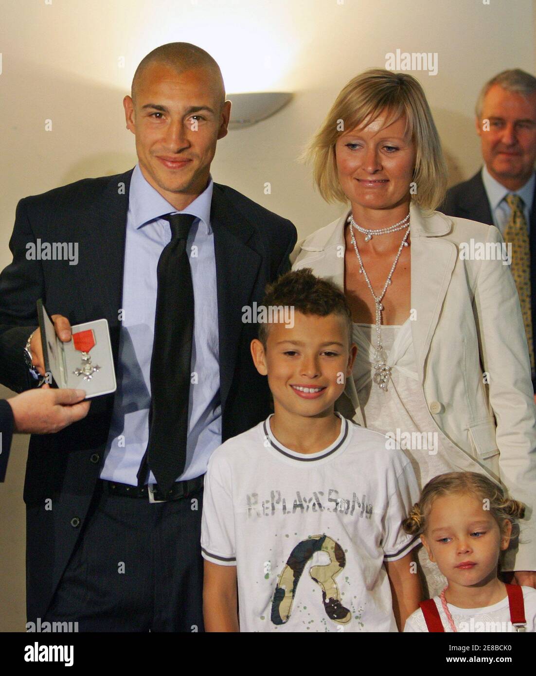 Barcelona's Henrik Larsson (L) from Sweden shows his Member of the Order of  the British Empire (MBE) medal with his wife Magdalena and children Jordan  (C) and Janelle (R) at the Nou