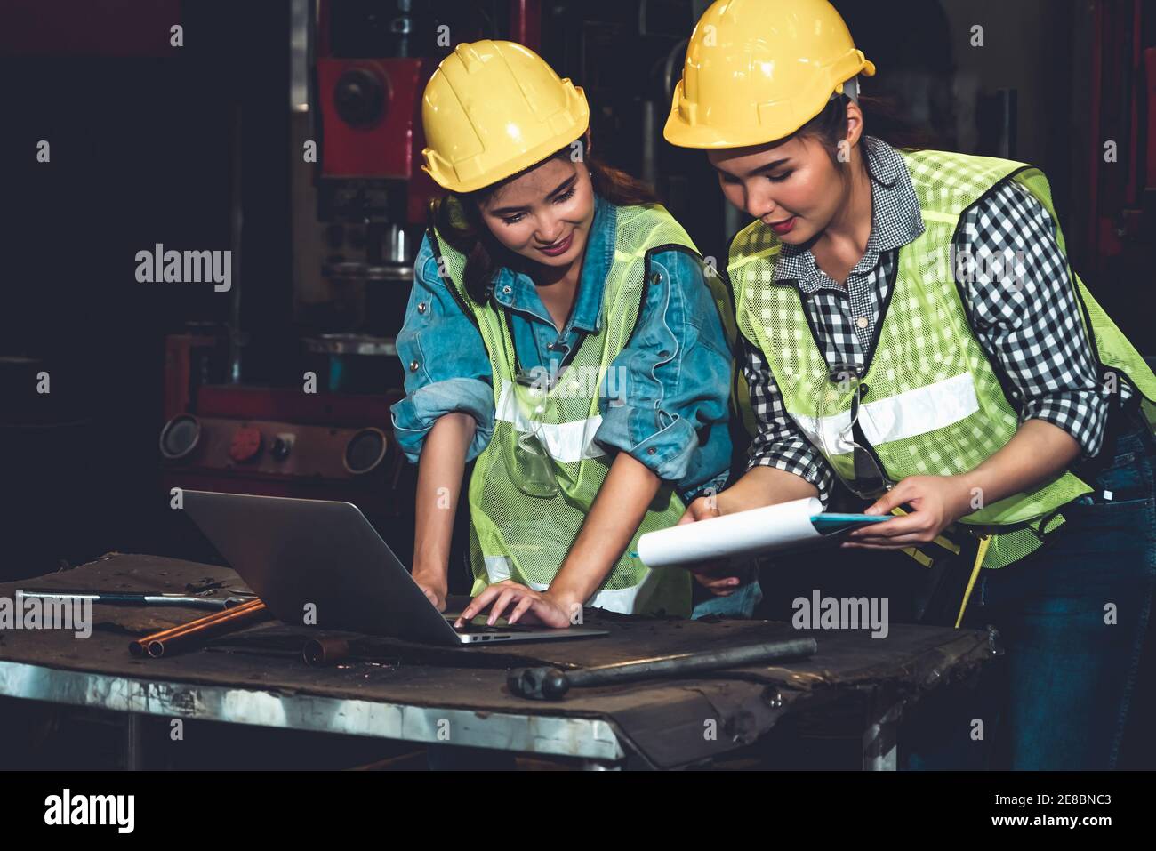 Factory job workers working and discussing manufacturing plan in the