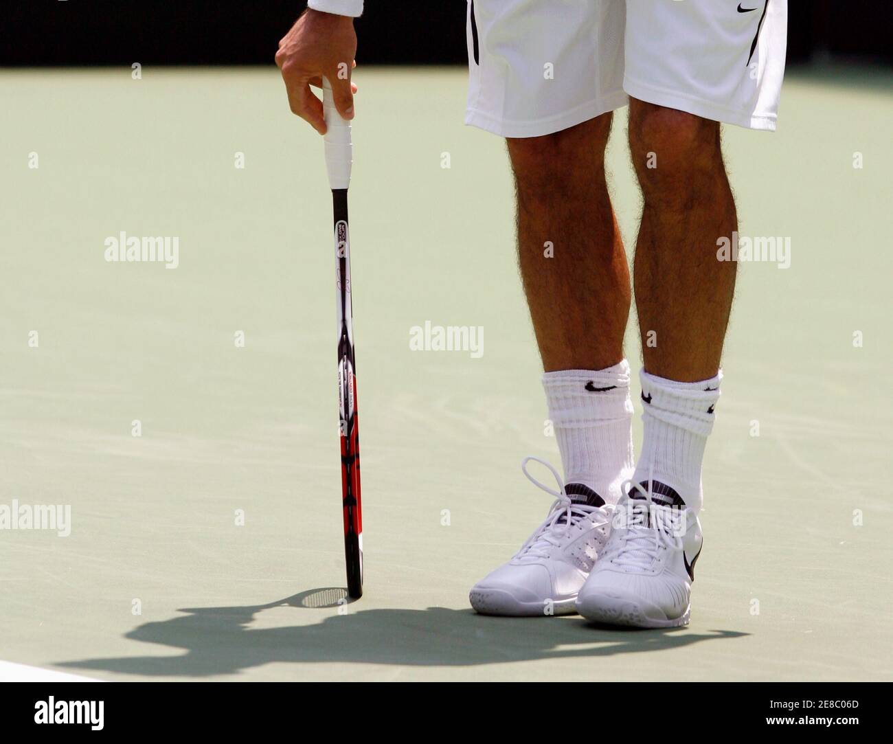 Switzerland's Roger Federer looks down at his feet after changing his socks  during his match against Germany's Bjorn Phau at the Australian Open tennis  tournament in Melbourne January 15, 2007. REUTERS/David Gray (