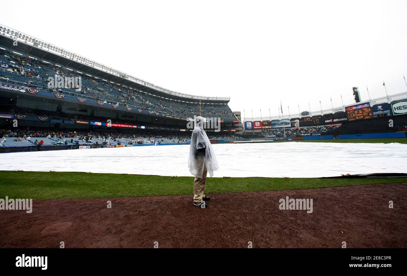 A Guard Stands Beside The Covered Infield At Yankee Stadium During A Rain Delay Before The Opening Day American League Baseball Game Between The Yankees And The Toronto Blue Jays In New