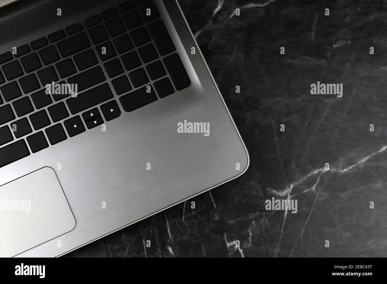 Laptop on black rough marble surface. Selective focus Stock Photo