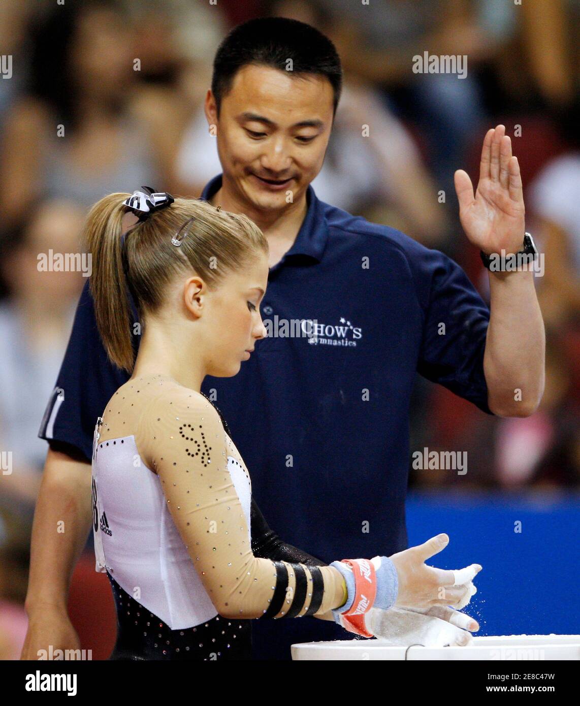 Shawn Johnson (front) listens to her coach Liang Chow before she competes  on the uneven bars at the . Women's Gymnastics Championships in Boston,  Massachusetts, June 7, 2008. REUTERS/Brian Snyder (UNITED STATES