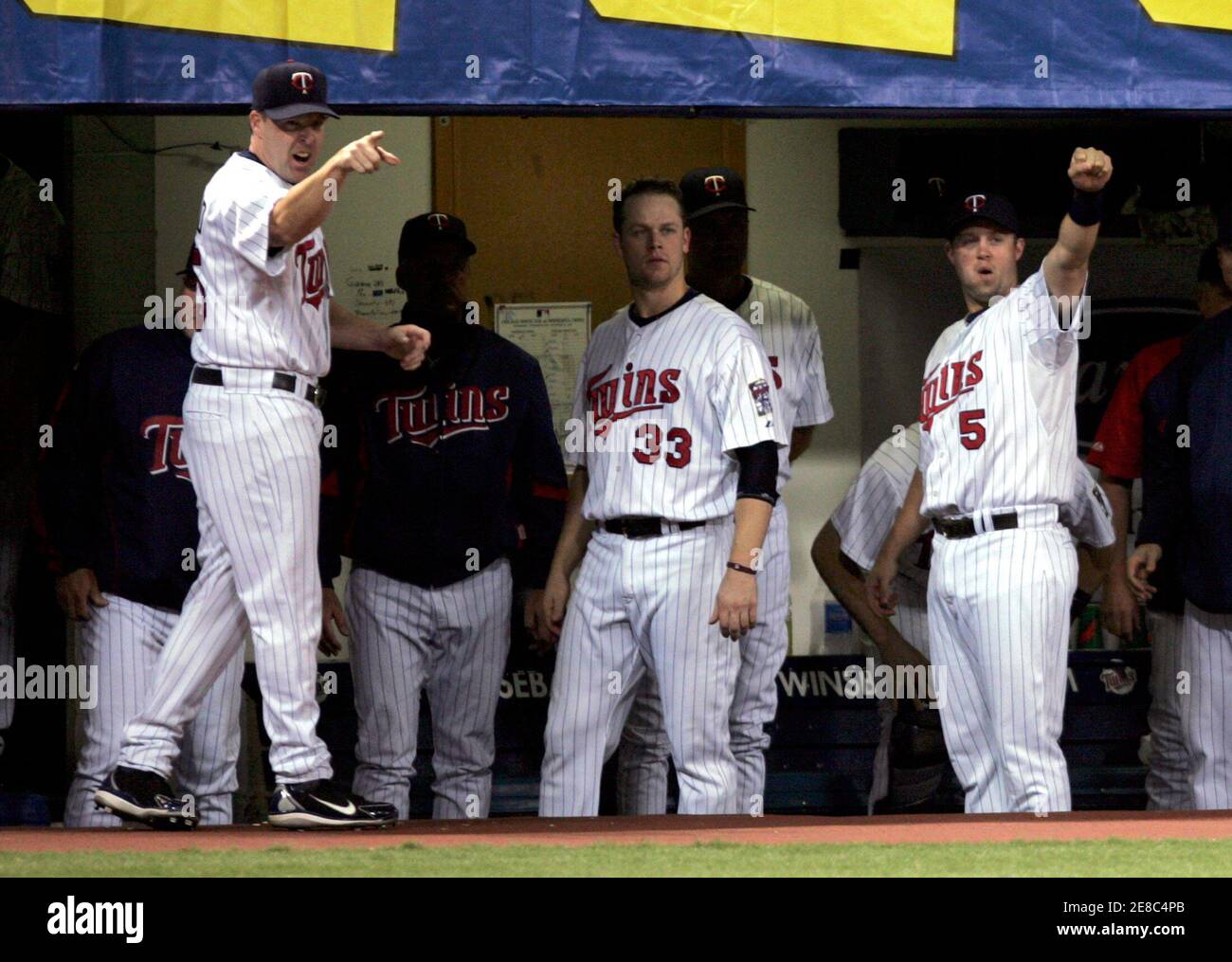 Minnesota Twins Mike Redmond (L), Justin Morneau (33) and Michael Cuddyer (5) cheer for teammate Nick Punto after Punto's squeeze bunt scores Twins Delmon Young from third base during the fourth inning of the Twins' American League baseball game against the Chicago White Sox at the Metrodome in Minneapolis September 23, 2008.    REUTERS/Eric Miller (UNITED STATES) Stock Photo