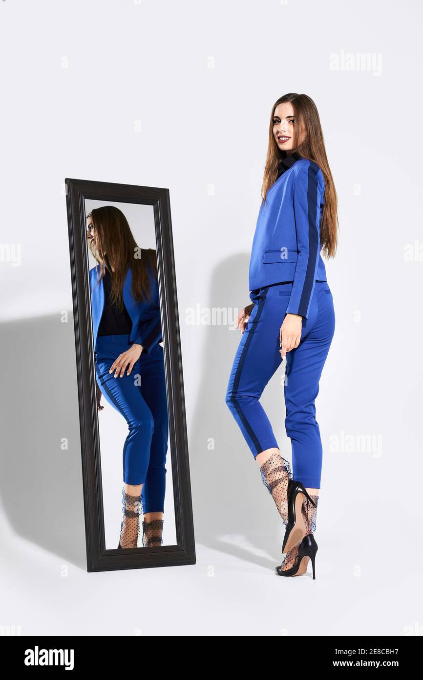 Stylish girl posing in pantsuit and tulle socks near the mirror Stock Photo