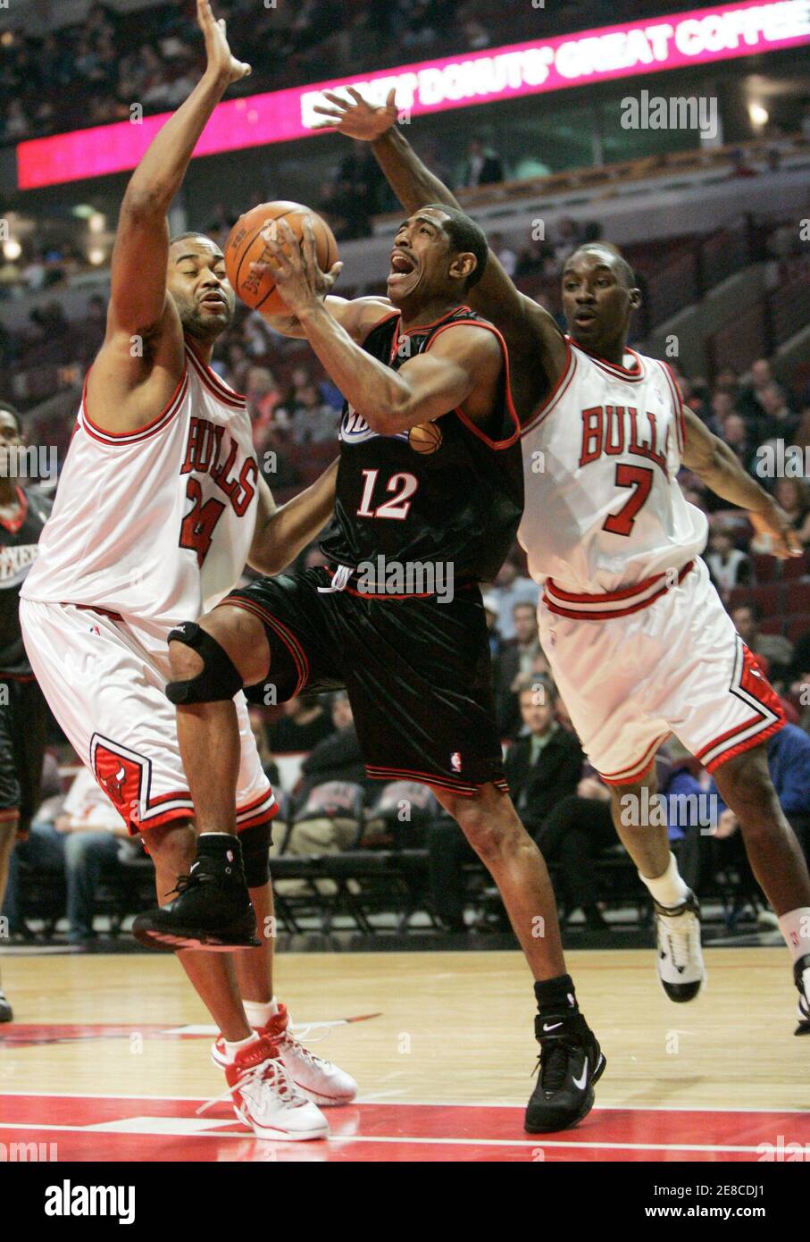 Philadelphia 76ers guard Kevin Ollie (C) drives between Chicago Bulls  Othella Harrington (L) and Ben Gordon during the first half of their NBA  game in Chicago, Illinois February 16, 2006. REUTERS/John Gress