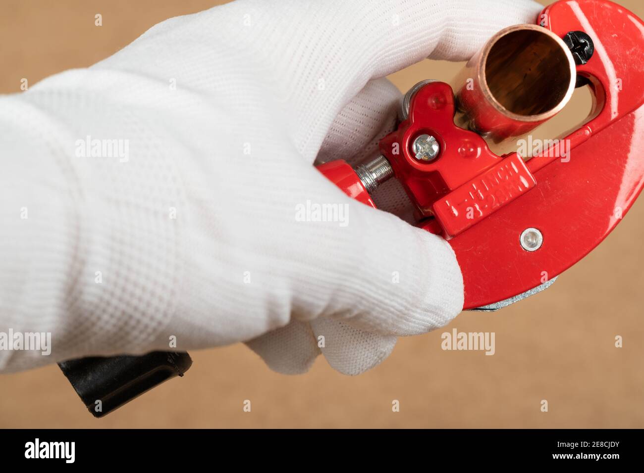 Cutting a copper pipe with a red pipe cutter Stock Photo Alamy