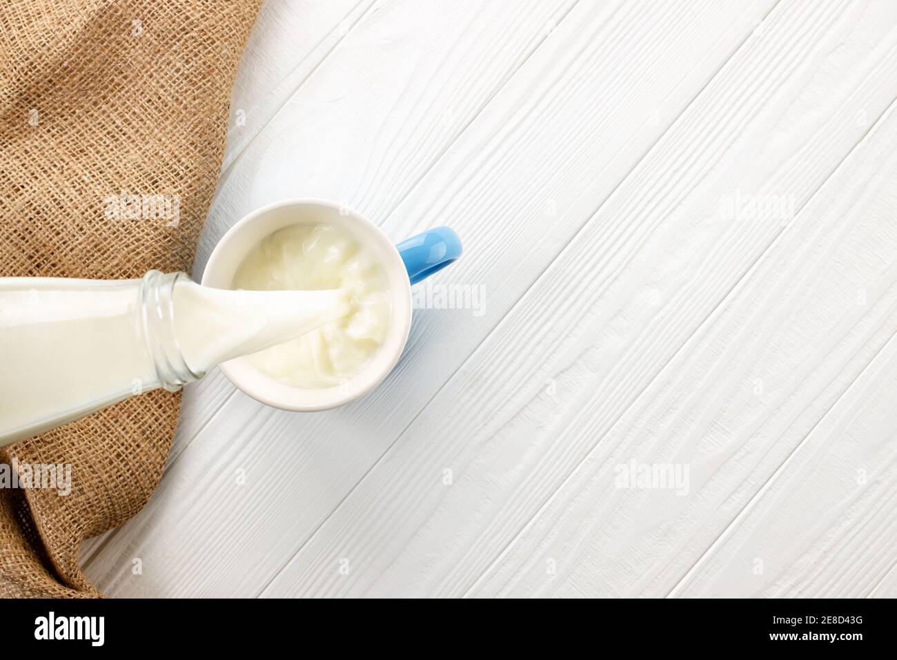 milk pouring into cup Stock Photo
