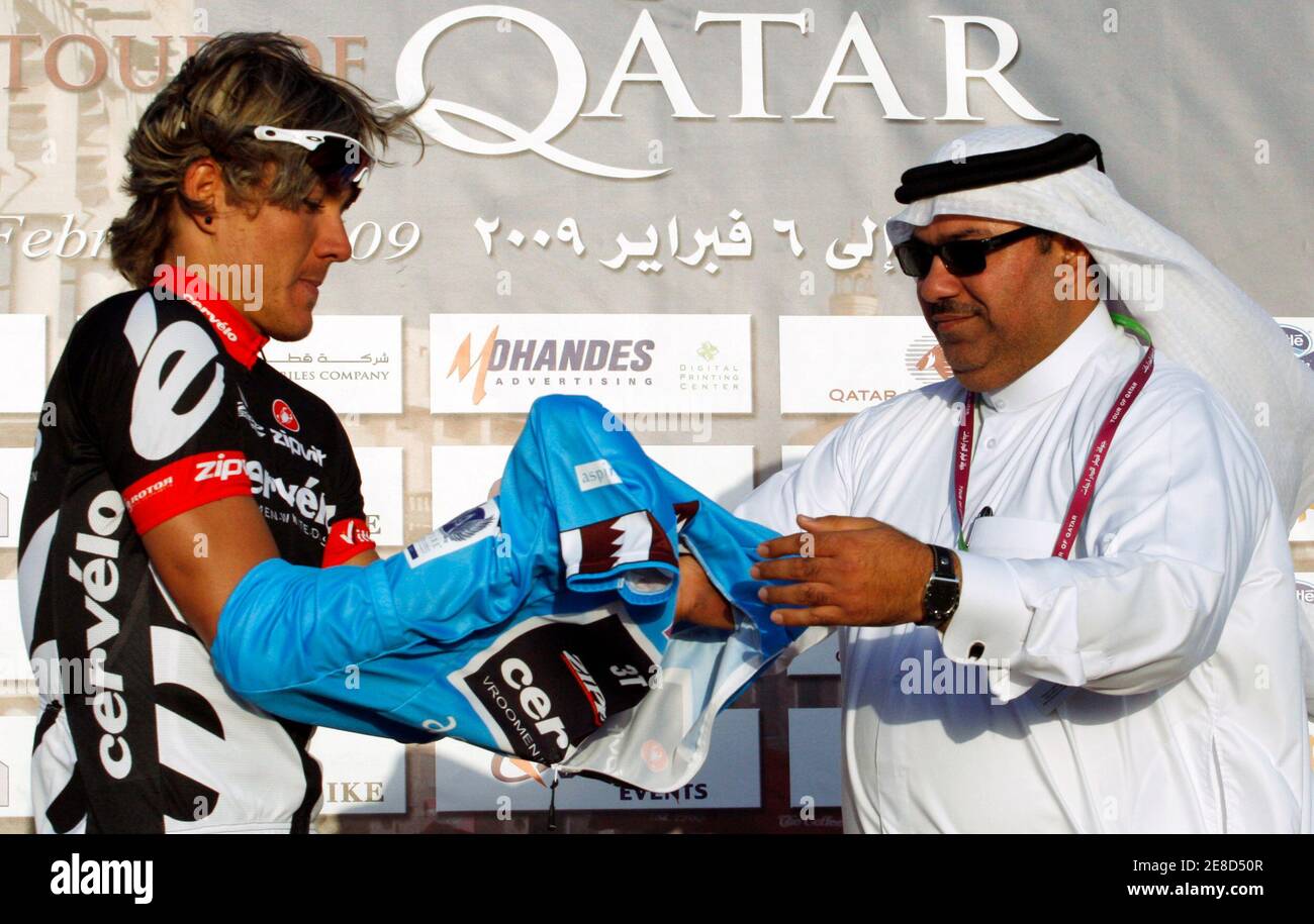 Member of the board of Qatar Cycling Federation Mohammed Salem (R) puts the  blue jersey on Cervelo Test Team rider Heinrich Haussler of Germany after  the 134km (83 miles) second stage of