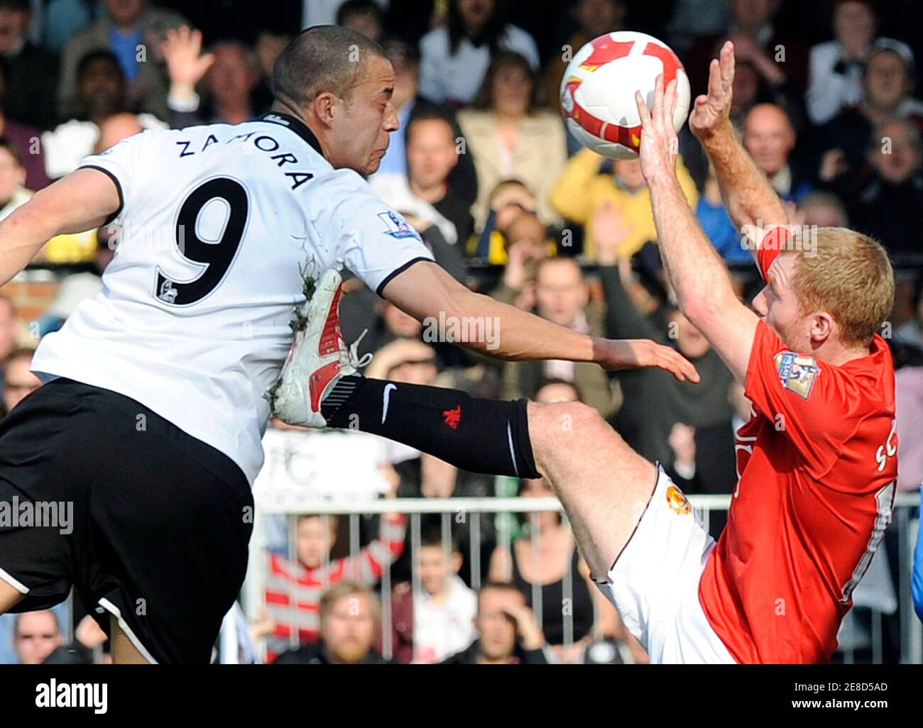 Manchester United's Paul Scholes (R) commits a handball foul and concedes a  penalty and is red-carded as Fulham's Bobby Zamora (L) heads goalwards  during their English Premier League soccer match against Fulham