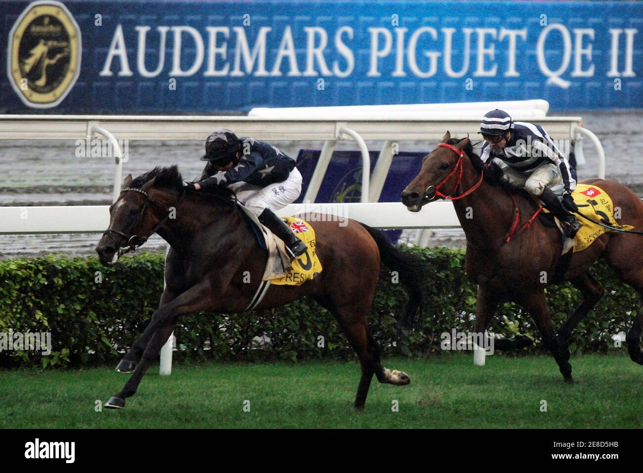 British jockey Ryan Moore riding Presvis (L) and French jockey Eric Saint-Martin riding Packing Winner compete in the 2,000m Audemars Piguet QE II cup at Hong Kong's Sha Tin racecourse April 26, 2009.    REUTERS/Tyrone Siu    (CHINA SPORT EQUESTRIANISM) Stock Photo