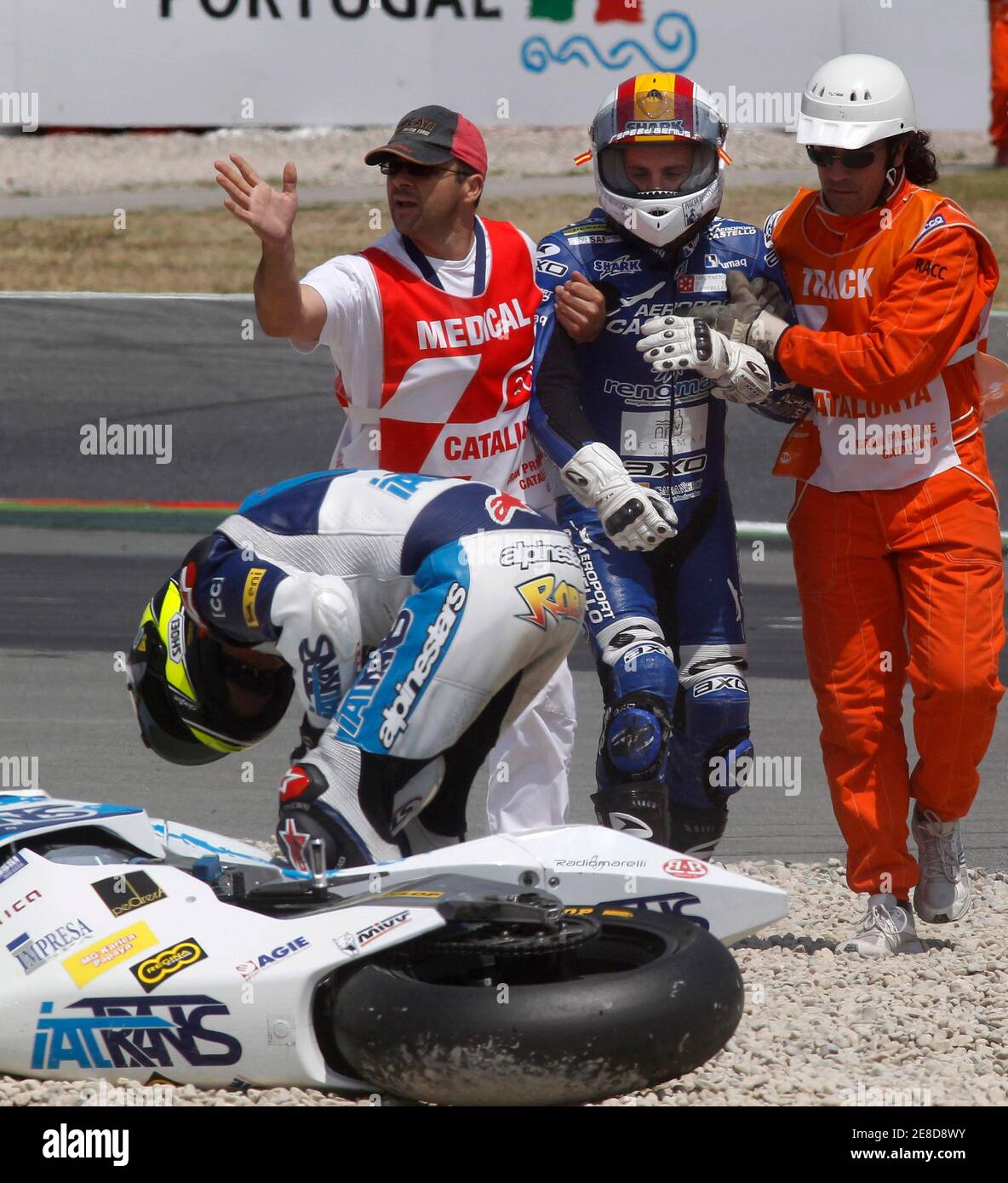 FTR Moto2 rider Alex Debon of Spain is assisted by medical staff next to  Suter Moto2 rider Roberto Rolfo of Italy after they were involved in a crash  with seven other riders