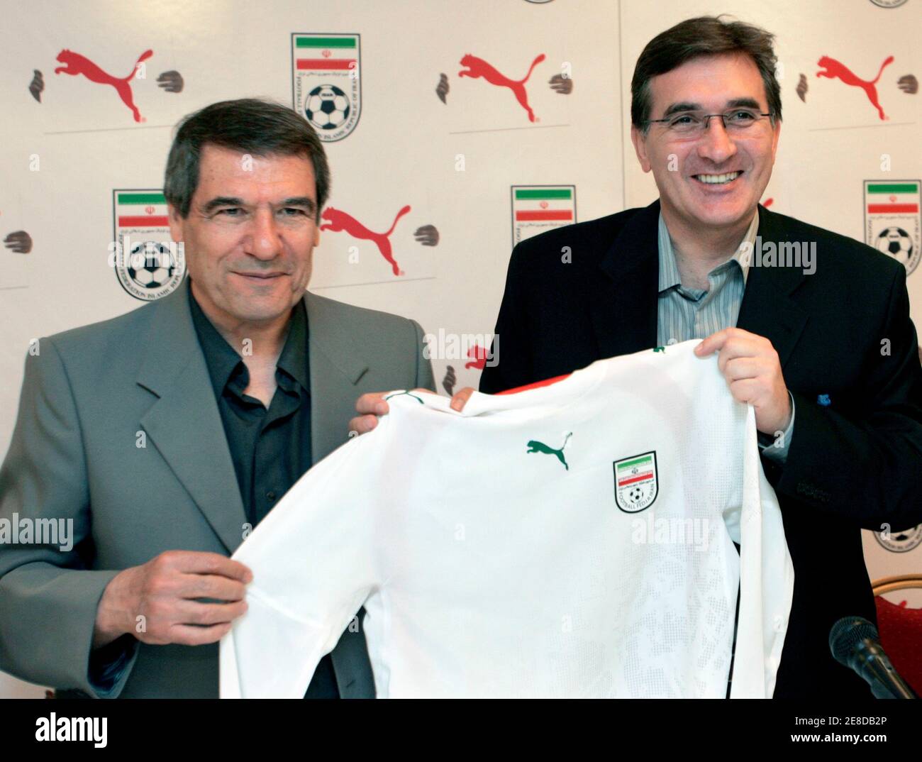 WORLD CUP 2006 PREVIEW Iran national soccer team head coach Branco Ivankovic (R) and assistant Homayoun Shahrokhi hold up a proposed team jersey for the 2006 World Cup during a ceremony in Tehran, Iran April 23, 2006. REUTERS/Raheb Homavandi Stock Photo