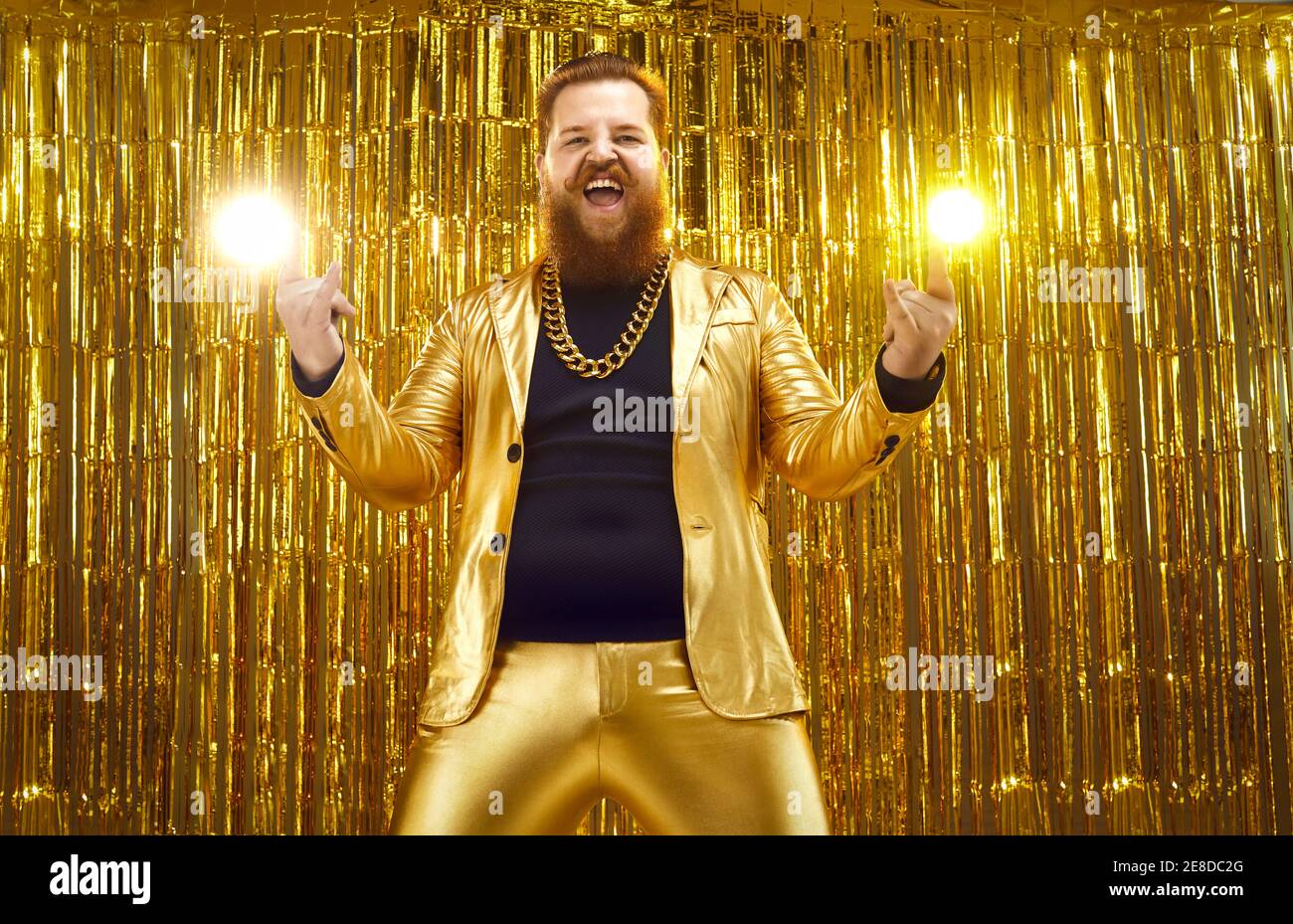Funny crazy bearded chubby man in shiny golden suit having fun at disco club party Stock Photo