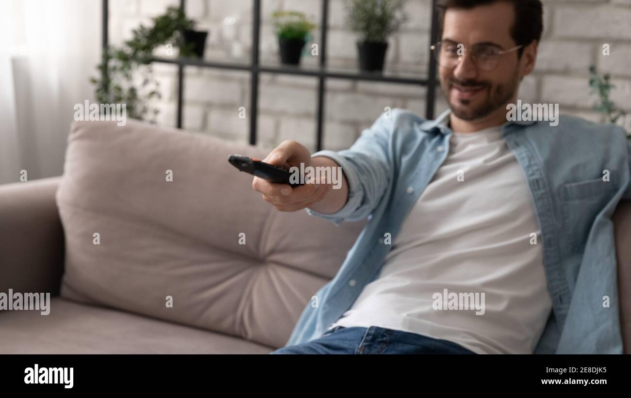 Close up man wearing glasses using remote tv controller Stock Photo