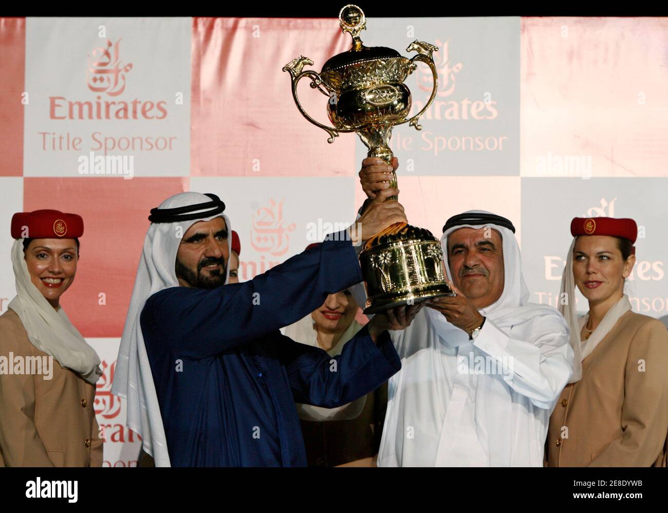 UAE Vice President and Prime Minister and Ruler of Dubai His Highness Sheikh Mohammed bin Rashid Al Maktoum (L) hands the Dubai World Cup to Sheikh Hamdan Bin Rashid Al Makhtoum after his horse Invasor won the Dubai World Cup March 31, 2007. The Dubai World Cup, with a cash prize of $6 million, is horse racing's richest prize.  REUTERS/Caren Firouz   (UNITED ARAB EMIRATES) Stock Photo
