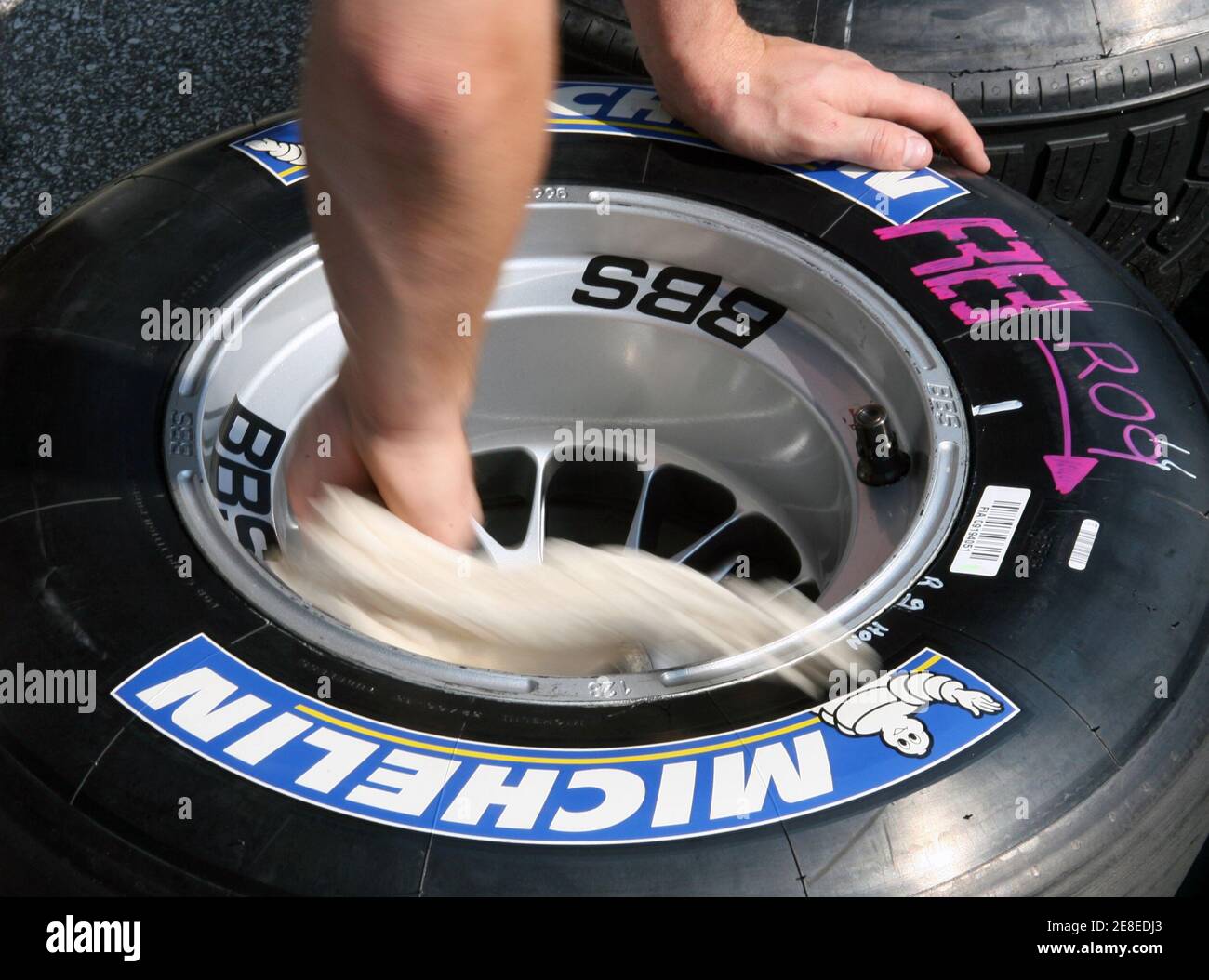 Honda team mechanic Paul Harris wipes clean a Michelin tire in the pits  during the U.S. Formula One Grand Prix weekend in Indianapolis June 29,  2006. The spotlight this weekend will be