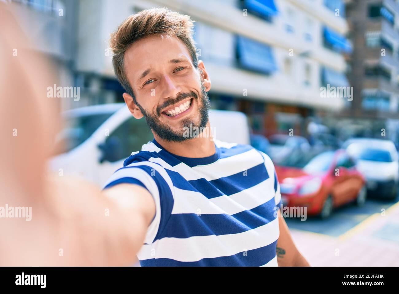 Handsome caucasian man with beard smiling happy taking a selfie picture ...