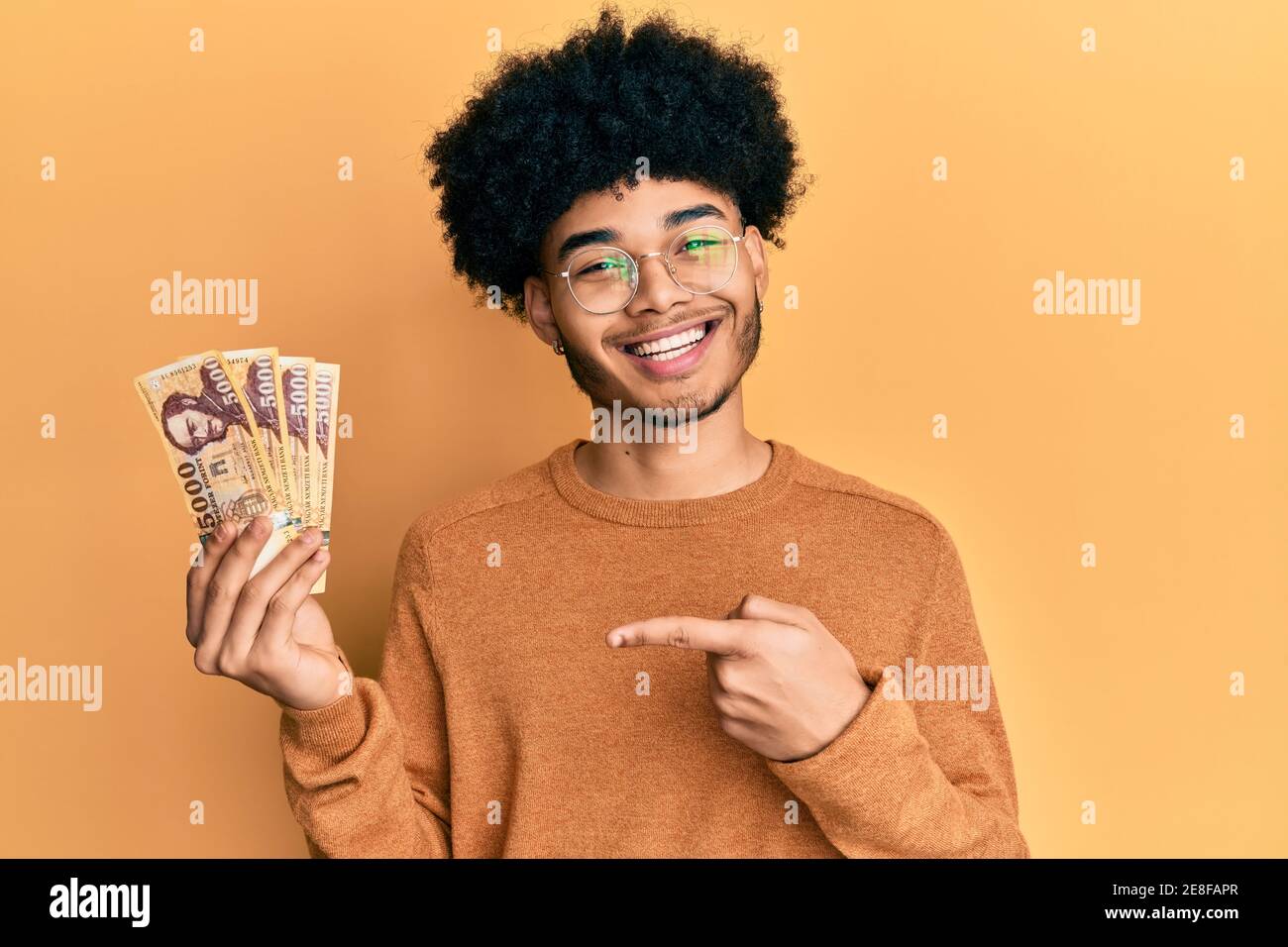 young-african-american-man-with-afro-hair-holding-5000-hungarian-forint