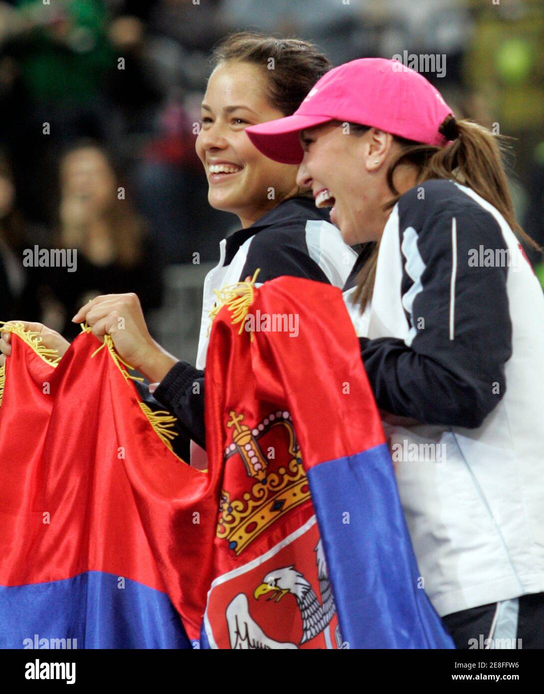 Serbia's Ana Ivanovic (L) and Jelena Jankovic pose with a Serbian flag after their victory against Japan at the Fed Cup World Group II, first round tennis tournament in Belgrade February 8, 2009.  REUTERS/Ivan Milutinovic   (SERBIA) Stock Photo