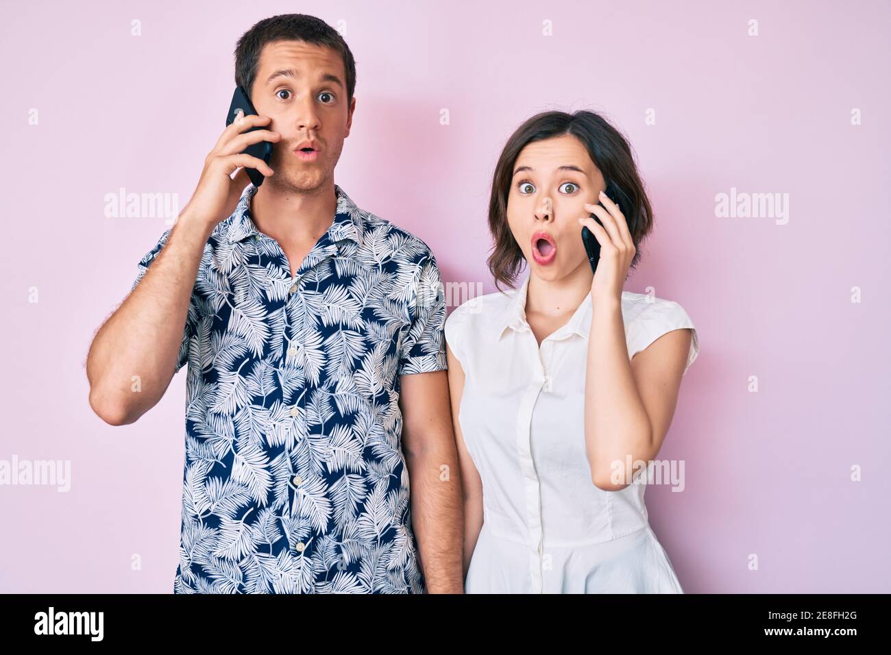 Beautiful couple having conversation talking on the smartphone scared ...