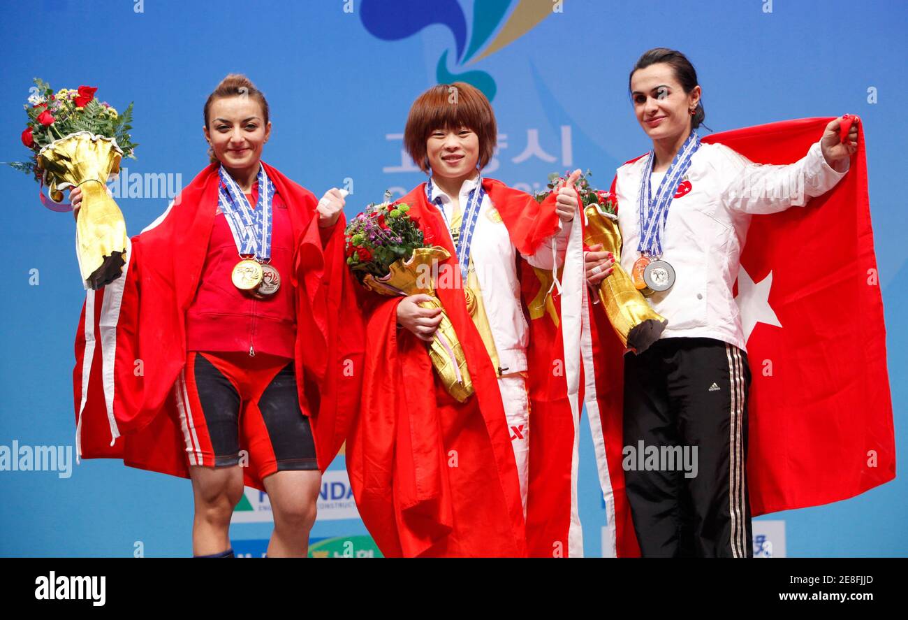 (L-R) Silver medallist Sibel Ozkan of Turkey, gold medallist Wang Mingjuan of China and bronze medallist Nurcan Taylan of Turkey pose on the podium in the women's 48kg competition at the World Weightlifting Championship in Goyang, north of Seoul, November 21, 2009.  REUTERS/Jo Yong-Hak (SOUTH KOREA SPORT WEIGHTLIFTING) Stock Photo
