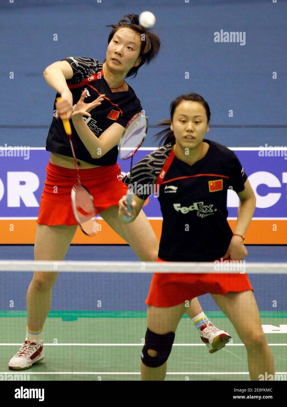 China's Cheong Shu (L) returns a shot as her team mate Zhao Yunlei watches during their women's doubles semi-final match against South Korea's Lee Kyung-won and Ha Jung-Eun at the Victor Korea Open Badminton Super Series in Seoul January 16, 2010.  REUTERS/Jo Yong-Hak (SOUTH KOREA - Tags: SPORT BADMINTON) Stock Photo