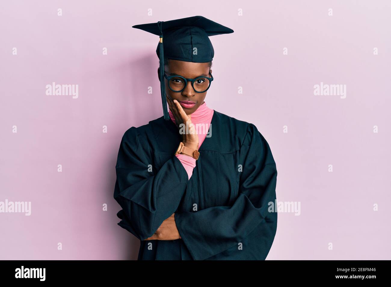 Young african american girl wearing graduation cap and ceremony robe thinking looking tired and bored with depression problems with crossed arms. Stock Photo