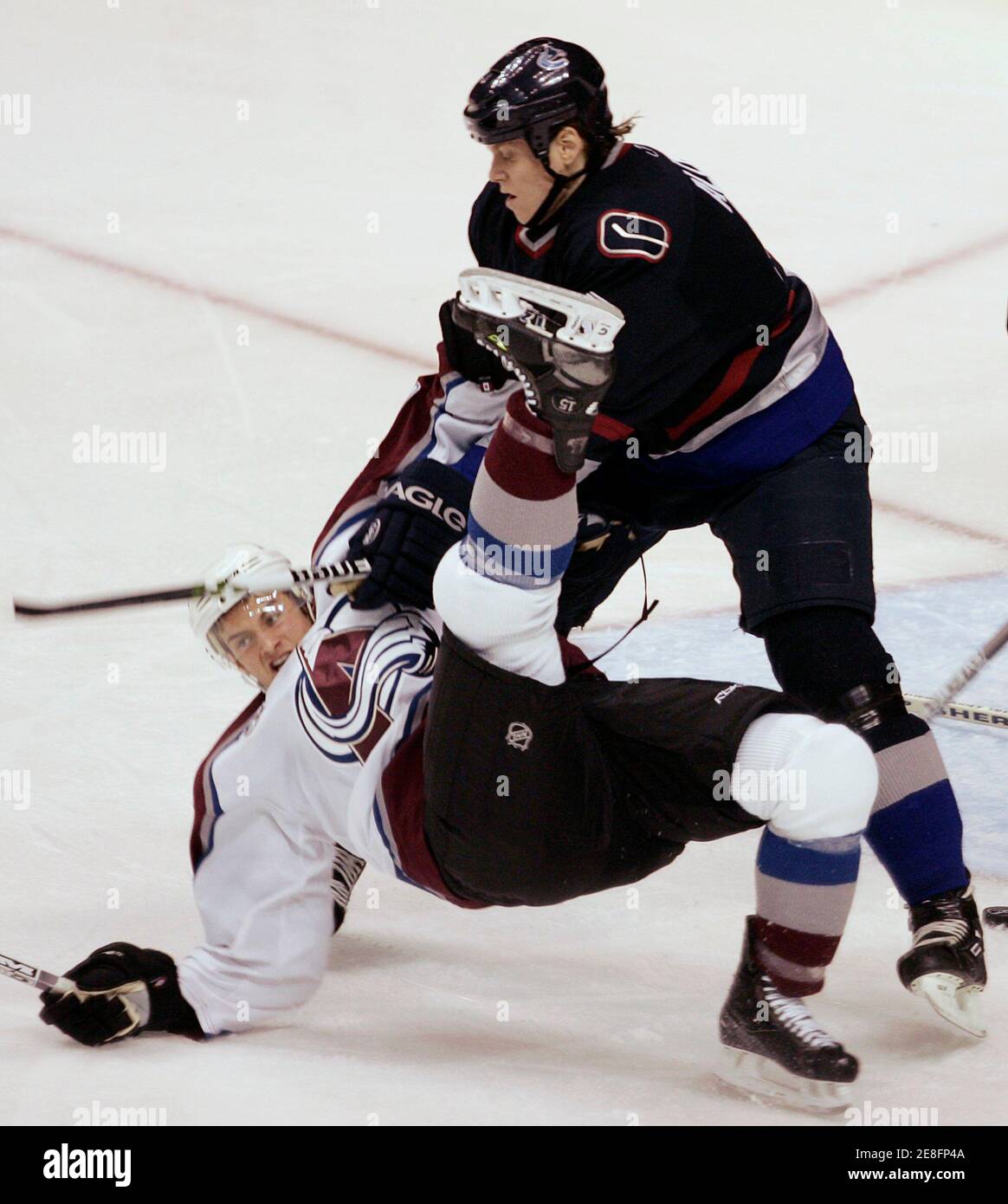 Colorado Avalanche Brad Richardson (L) is knocked to the ice by Vancouver Canucks Bryan Allen during first period NHL play in Vancouver, British Columbia, November 30, 2005. REUTERS/Andy Clark Stock Photo