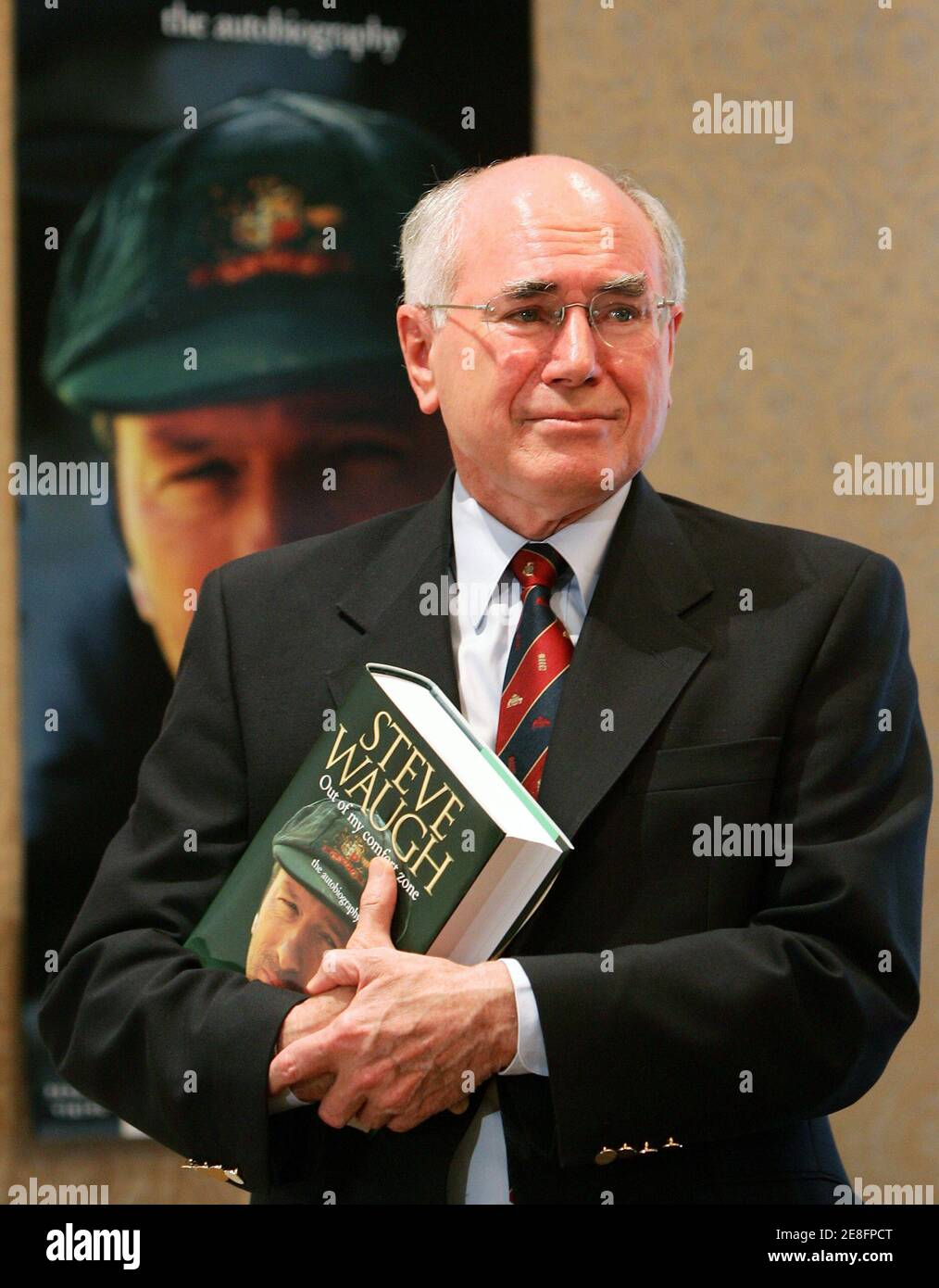 Australia's Prime Minister John Howard holds his copy of former Australian cricket team captain Steve Waugh's autobiography after launching the book in Sydney October 23, 2005. Waugh, Australia's Test cricket captain from 1999 to 2004, has penned the book entitled 'Out of My Comfort Zone' in which he reveals insights into life on and off the field during the time he headed a dominant team. REUTERS/Will Burgess Stock Photo