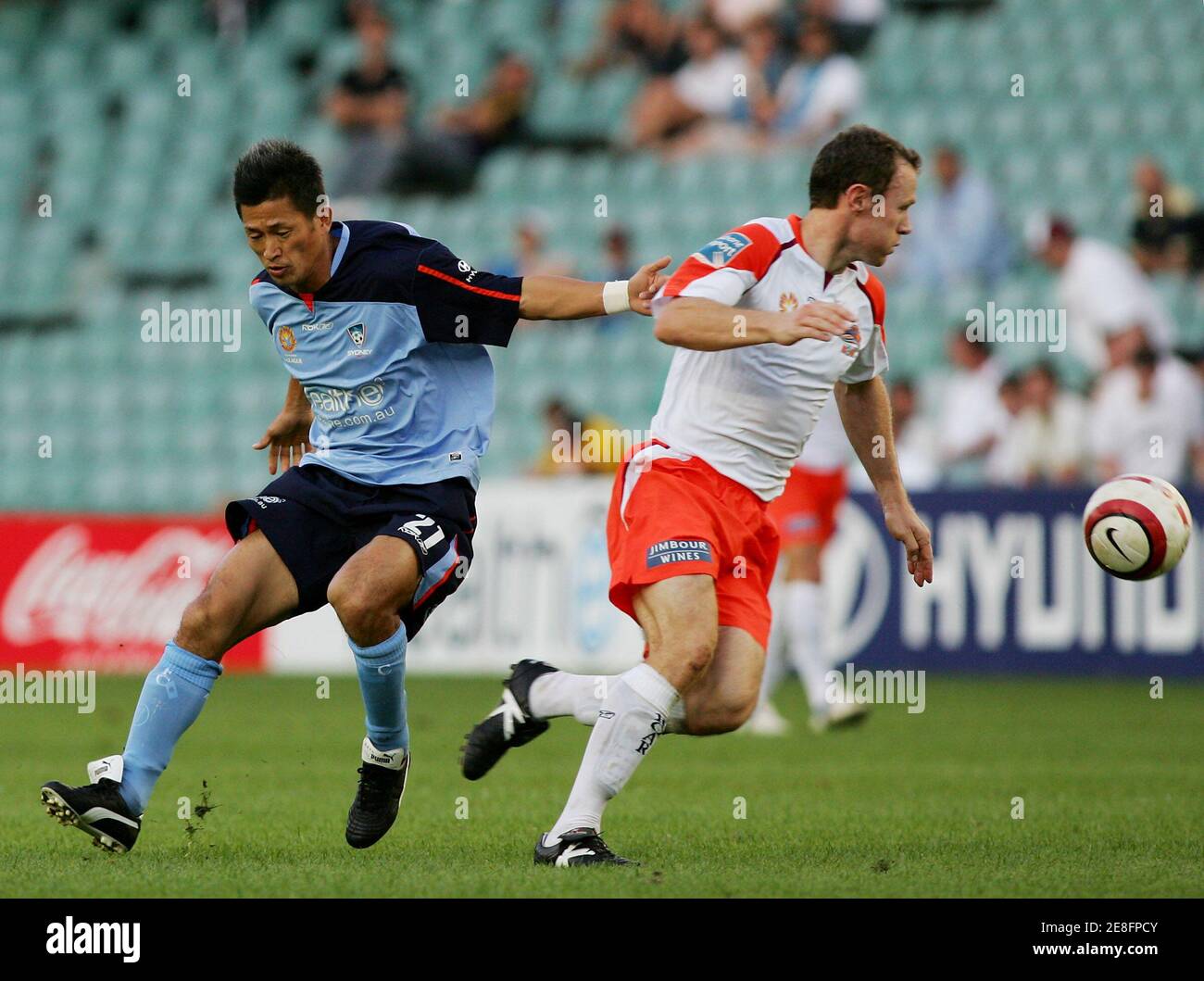 Sydney FC Japanese soccer star Kazuyoshi 'Kazu' Miura (L) loses the ball to Queensland Roar's Stuart McLaren during his first Australian A-League soccer match in Sydney November 13, 2005. Miura will play four matches before joining Sydney FC's FIFA Club World Championship soccer competition in Japan from December 11-18. REUTERS/Will Burges Stock Photo