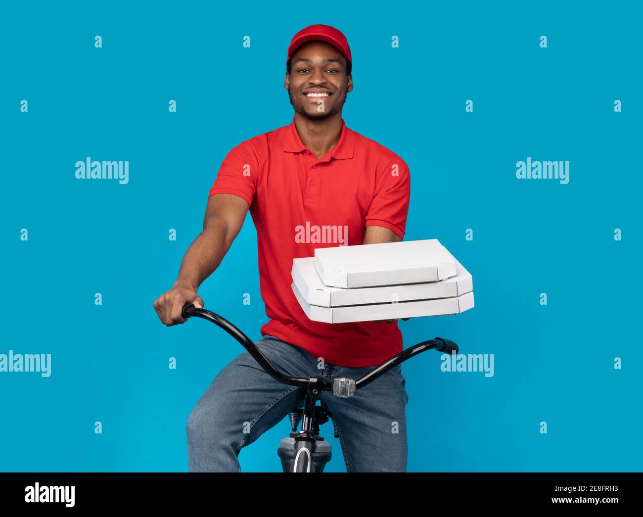 Black delivery man holding pizza boxes, riding bicycle Stock Photo Alamy