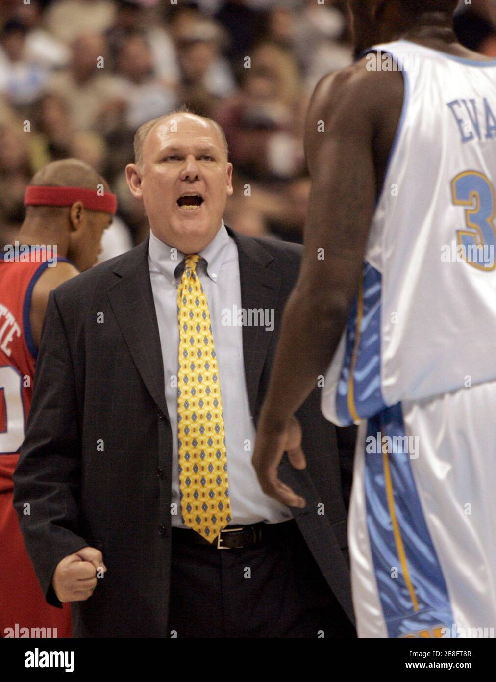 Denver Nuggets head coach George Karl (C) speaks to Nuggets forward Reggie Evans (R) in the third quarter of the Nuggets' 100-86 loss to the Los Angeles Clippers in game 4 of the NBA playoff series in Denver April 29, 2006. The Clippers lead the series 3-1. REUTERS/Rick Wilking Stock Photo